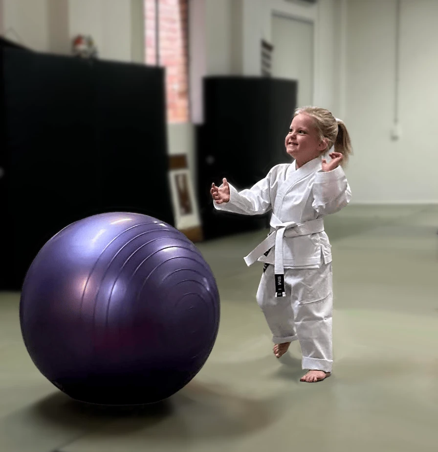 A tiny tot sitting respectfully on the mat